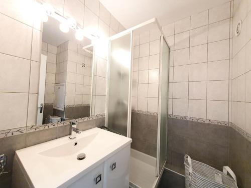 a bathroom with a sink and a mirror at Résidence Les Carlines - Studio pour 4 Personnes 664 in Les Orres