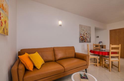 - un salon avec un canapé brun et une table dans l'établissement Apartments Kvarner 2, à Malinska