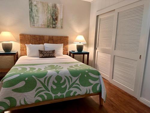 a bedroom with a bed with a green and white bedspread at North Shore of Maui - 2bd-2bath in Paia