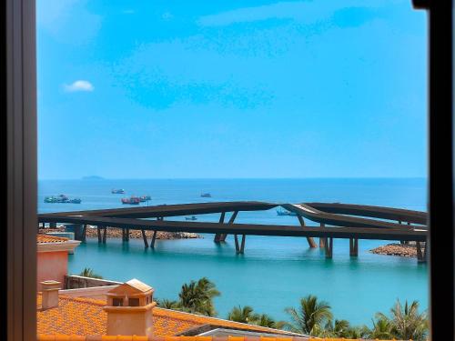 a bridge over a body of water next to the ocean at Sunset Hotel Phu Quoc - welcome to a mixing world of friends in Phu Quoc