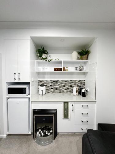 uma cozinha branca com um fogão e uma lareira em Sheer Pleasure Accommodation em Smithton
