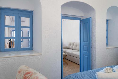 Habitación con puerta azul y sofá en Aggelikis Traditional Cave House, en Mesariá