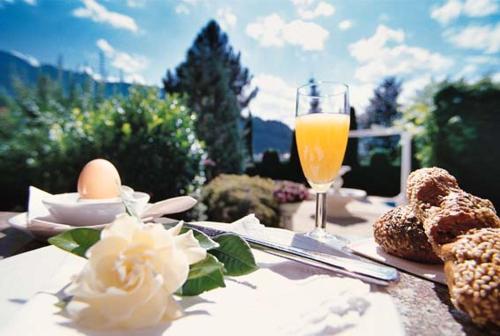 a table with a glass of orange juice and some food at Boutiquehotel Säumler in Zell am Ziller