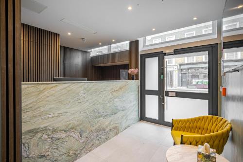 a lobby with a counter and a yellow chair at St Pancras Inn in London