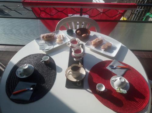 einen weißen Tisch mit einem Teller Essen drauf. in der Unterkunft House1919 Via Valmara 14 in Brissago