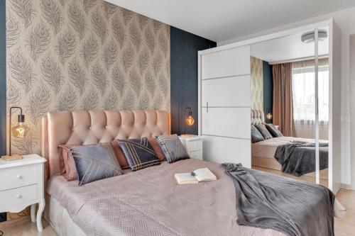 a bedroom with a large bed with a large headboard at Tower View Apartment in Vilnius