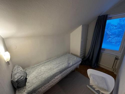 a small bedroom with a bed and a window at Mysig Takvåning med takfönster in Ljungaverk