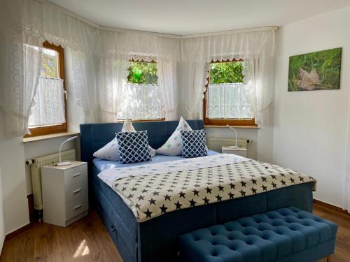 a bedroom with a blue bed and a blue bench at Pension Höchemer in Bad Bocklet