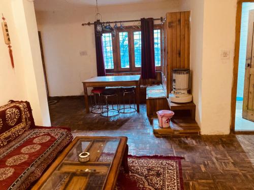 a living room with a table and a couch at Ganga Cottage !! 1,2,3 bedrooms cottage available near mall road manali in Manāli