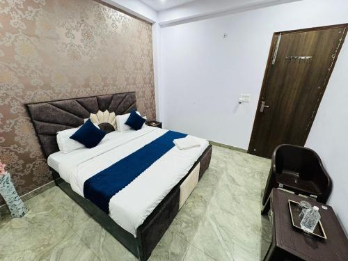 a bedroom with a bed with blue pillows and a mirror at Hotel Sapphire Grand - Onyx Plaza in Ghaziabad