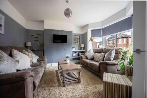a living room with two couches and a table at Beautiful 4 Bedroom House by the River in Southampton