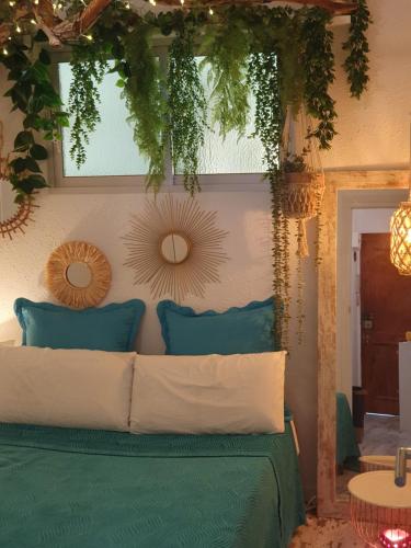 a bedroom with a green bed with mirrors on the wall at apartamento playa surf cullera in Cullera