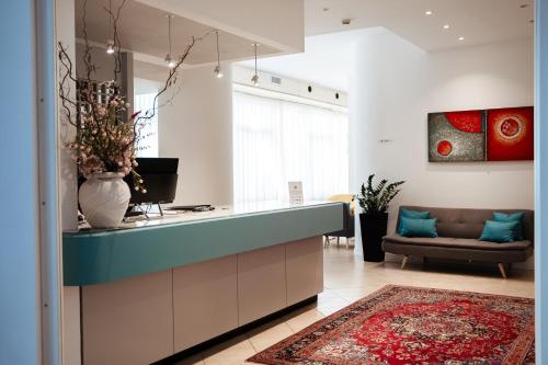 a kitchen with a blue counter and a living room at Hotel Niagara in Lido di Jesolo