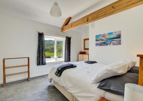a bedroom with a bed and a window at Carreg Cottage in Capel-Curig