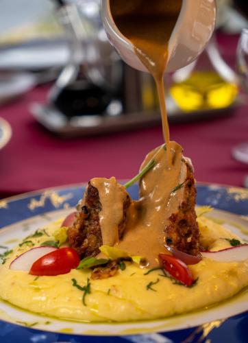 a sauce being poured onto a plate of food at Delta Nature Resort in Tulcea