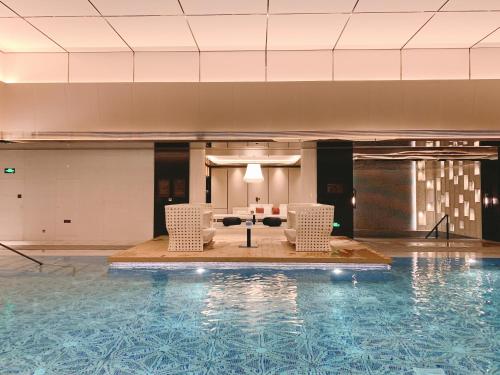 a pool with chairs and a couch in a building at The Ritz-Carlton, Xi'an in Xi'an
