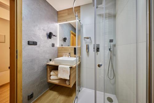 een badkamer met een wastafel en een douche bij Aparthotel Rýbrcoul in Trutnov