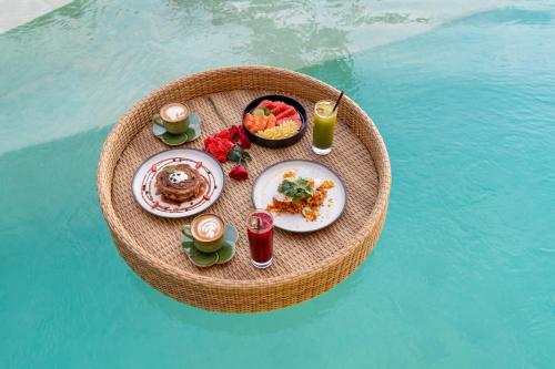 un tavolo con cibo e bevande su un tavolo rotondo nell'acqua di Morin Resort a Nusa Lembongan