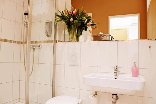 a bathroom with a sink and a toilet and a vase of flowers at Air in Berlin in Berlin