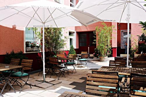 a patio with tables and chairs and an umbrella at Air in Berlin in Berlin