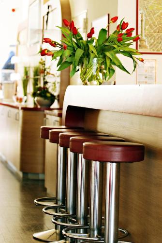 a group of stools with a table with flowers at Air in Berlin in Berlin