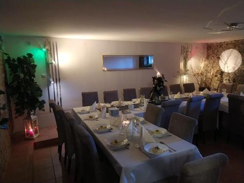 uma sala de jantar com uma mesa longa e cadeiras em Galeona - Hotel turystyczny em Elblag