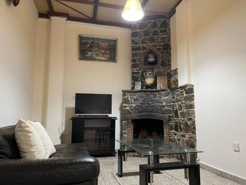uma sala de estar com uma lareira de pedra e um sofá de couro preto em Galata's Bridge Boutique Hotel em Galata