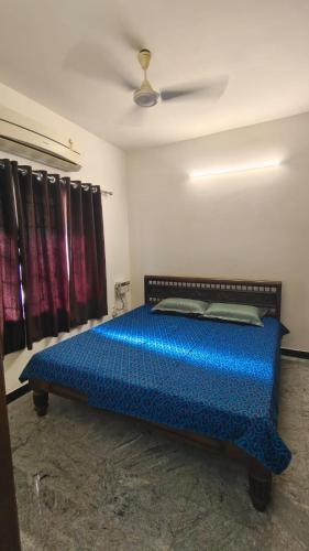 a bedroom with a blue bed in a room at HACIENDA APARTMENT in Chennai