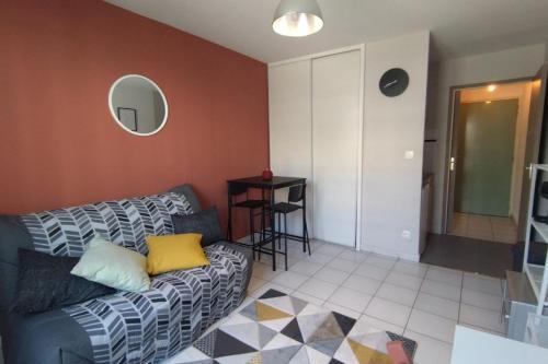 un salon avec un canapé et une table dans l'établissement Charming studio in Avignon, à Avignon