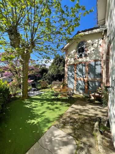 a yard with a picnic table and a tree at Maison de charme avec jardin - Proche Lyon - in Vienne