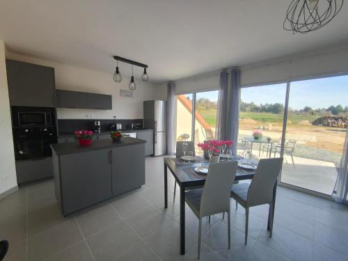 une cuisine et une salle à manger avec une table et des chaises dans l'établissement Perroquet & Koala 2 logements 10min du zoo de Beauval et proche château, à Saint-Romain-sur-Cher