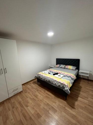ein Schlafzimmer mit einem Bett und einem Holzboden in der Unterkunft Apartman Dušan Trebinje in Trebinje