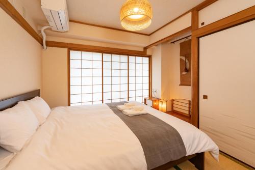 um quarto com uma cama e uma grande janela em CoCoHouse Asakusa - SkyTree View, 72㎡ em Tóquio