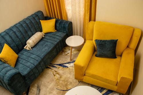 Ultimate Elegance في Embu: غرفة معيشة مع أريكة زرقاء وكرسي اصفر