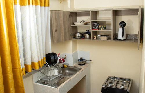 EmbuにあるUltimate Eleganceのキッチン(シンク、黄色のカーテン付)