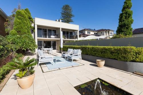 a patio with two chairs and a fountain in front of a house at King Bedroom Waterfront Courtyard Apartment in Sylvania
