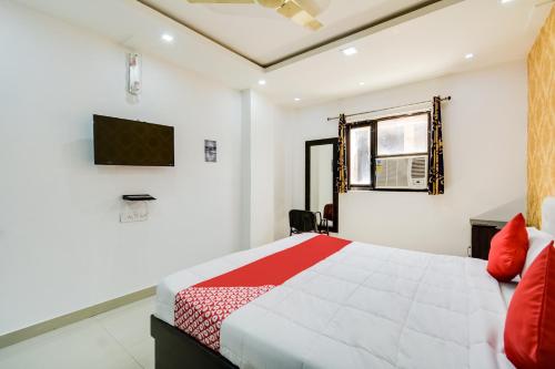 a bedroom with a bed and a tv on the wall at OYO Hotel Amber Palace in Bārmer