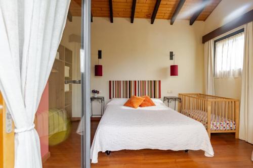 Almarinae apartamentos في Castiello de la Marina: غرفة نوم بسرير وملاءات بيضاء ومخدات برتقالية