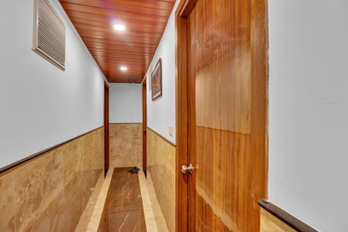 un pasillo con una puerta de madera en una casa en OYO Hotel Royal Park, en Bombay