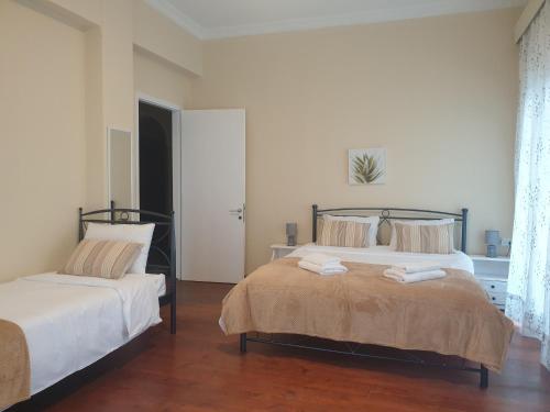 a bedroom with two beds with towels on them at Great View City Appartment in Agios Rokkos