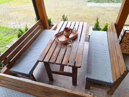 a wooden bench and two chairs on a porch at Vila Pohoda Javorníky s rozľahlým pozemkom in Makov