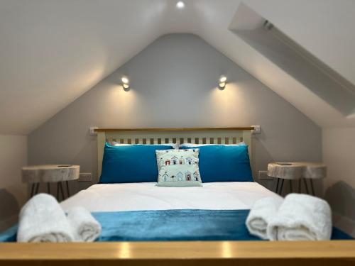1 dormitorio con 1 cama con sábanas azules y toallas en No. 75, en Pakefield