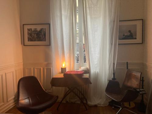 une pièce avec une bougie posée sur une table à côté d'une fenêtre dans l'établissement Garden Green, à Paris