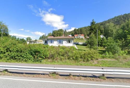 una casa sentada al costado de un camino en Furuly by Norgesbooking - cabin 20 meters from the beach, en Hyggen