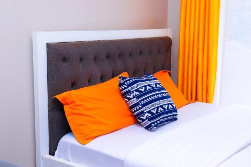 a bed with two pillows on top of it at Comfy Studio Apartment with Pool in Nairobi