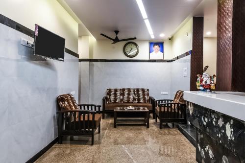 una sala de espera con sillas y un reloj en la pared en OYO The Elite Inn en Visakhapatnam
