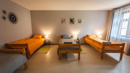 a bedroom with two beds and two chairs and a window at Barona spilvens in Kazdanga