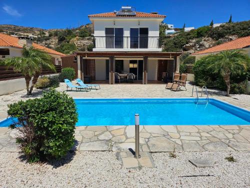 a house with a swimming pool in front of a house at Villa Penny in Pissouri