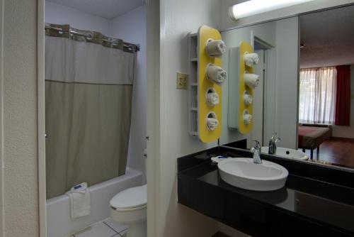 Motel 6-West Monroe, LA في ويست مونرو: حمام مع حوض ومرحاض ومرآة