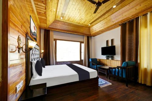 a bedroom with a bed and a desk and a television at OYO Itm Elysian in Vashisht